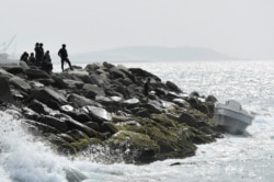 Security forces guard the shore area and a boat in which authorities claim a group of armed men landed in the port city of La Guaira, Venezuela, May 3, 2020.