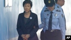 FILE - In this Oct. 10, 2017 file photo, Former South Korean President Park Geun-hye, left, arrives to attend a hearing on the extension of her detention at the Seoul Central District Court in Seoul, South Korea.