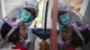 Seorang petugas medis melakukan test swab COVID-terhadap seorang anak di Surabaya (foto: AFP). RRI menutup siaran di Zona Merah termasuk RRI Surabaya. 