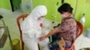 Petugas medis mengenakan APD mengambil sampel darah untuk pemeriksaan tes cepat salah satu anggota Panitia Pemungutan Suara di Puskesmas Kecamatan Lage, Kabupaten Poso, Sulawesi Tengah, 25 Juni 2020. (Foto: KPU Kabupaten Poso)
