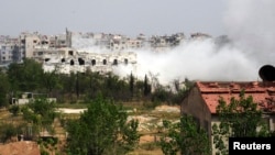 Smoke rises from a part of the Mleha town in the suburb of Damascus during the clashes between rebel fighters and forces loyal to Syria's President Bashar al-Assad, April 12, 2014.