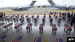 Los ataúdes cubiertos con la bandera de EE.UU. conteniendo los restos de 55 soldados estadounidenses son vistos a su arribo a la base Pearl Harbor-Hickman, en Honolulu, Hawái, el miércoles, 1 de agosto de 2018.