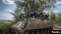 Ukrajinski vojnici voze se oklopnim transporterom M113 u blizini grada Bakhmuta na liniji fronta