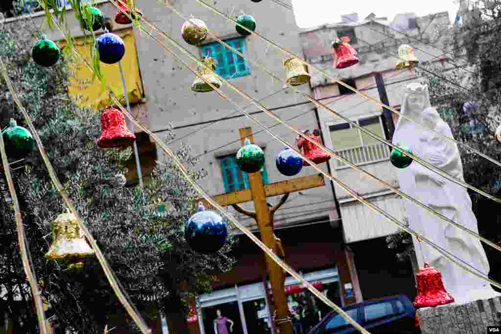 In Beirut's Armenian quarter, Christmas balls and bells near a statue of the Virgin Mary and Baby Jesus, Lebanon, December 2012. (VOA/V.Undritz)