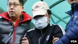 Penjaga Pantai Korea Selatan menggiring kapten kapal nelayan Tiongkok (tengah) pasca perawatan medis di rumah sakit Incheon (12/12).