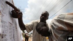 Residents check for their names on the voters registration list in Lagos, Nigeria, Friday, Feb. 18, 2011. Voters in oil-rich Nigeria are finding it hard to verify that they are on the registration list before the country's crucial April elections as few l