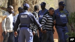 Police keep watch during the arrival of some of the 250 mine workers who were arrested when they had a shoot out with police, at a Garankuwa court outside Pretoria, South Africa, August 20, 2012. 