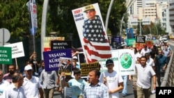 
Turkish supporters of Egypt's ousted president Mohamed Morsi hold portrait mocking General Abdel Fattah al-Sisi during demonstration condemning deadly crackdown in Cairo, outside Egyptian embassy, Ankara, August 14, 2013.