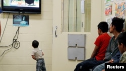 Anak-anak imigran ilegal yang dipisahkan dari orang tua mereka menonton film kartun di fasilitas penahanan imigrasi di Tucson, Arizona (foto: dok). 