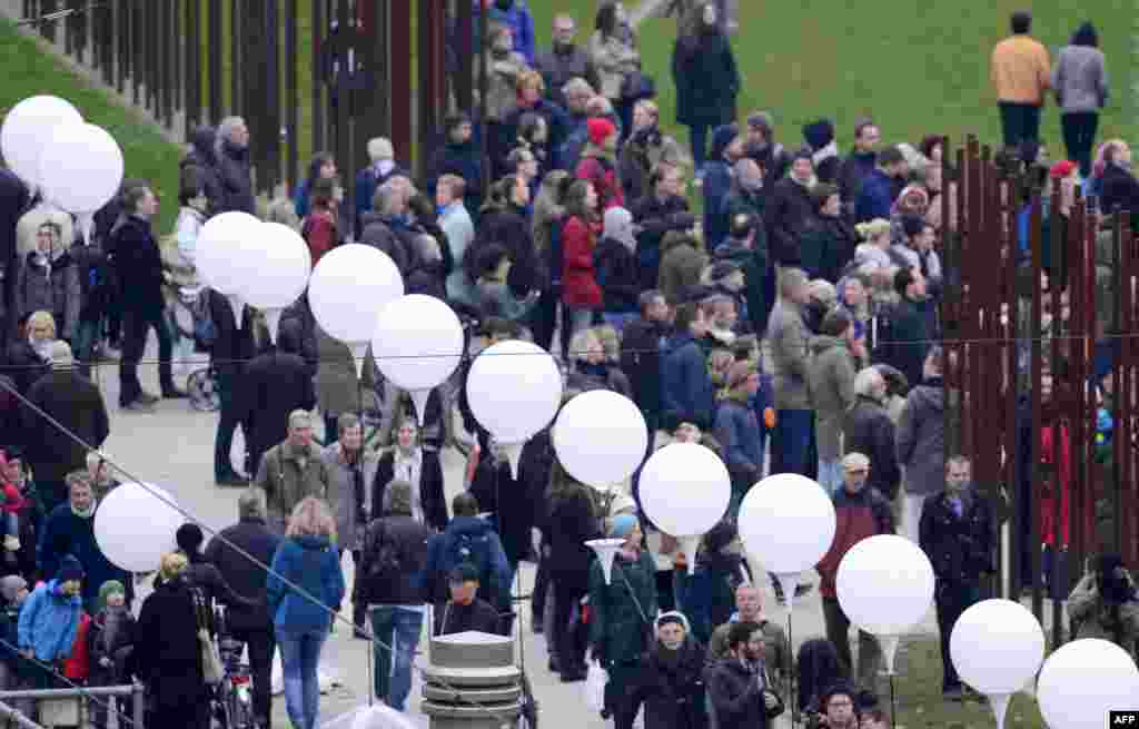 People gather along a light installation called Light Border ( Lichtgrenze ) featuring the Berlin Wall during commemorations to mark the 25th anniversary of the fall of the Berlin Wall at the Berlin Wall Memorial in the Bernauer Strasse Berlin, Germany.