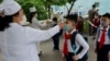 Anak-anak SD di Pyongyang, Korea Utara diperiksa suhu tubuhnya sebelum masuk ke kelas mereka (foto: dok). 