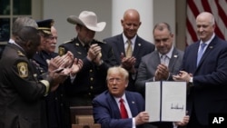 Para pejabat penegak hukum bertepuk tangan setelah Presiden Donald Trump menandatangani instruksi presiden tentang reformasi polisi, Rose Garden, Gedung Putih, Selasa, 16 Juni 2020. (Foto: AP Photo/Evan Vucci)
