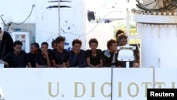 Les migrants attendent de débarquer du navire "Diciotti" au port de Catane, en Italie, le 22 août 2018. 