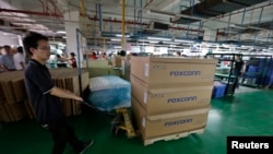Un homme pousse un chariot chargé de boîtes dans l'usine de Foxconn à Wuhan, dans la province de Hubei, le 31 août 2012. L'usine assemble des produits pour de nombreux fabricants de gadgets, dont Apple. (REUTERS/Stringer)