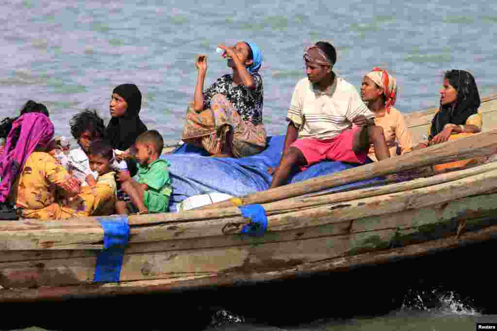 Muslim Rohingya people on a boat cross the river Naf, from Burma into Teknaf, Bangladesh, June 11, 2012.