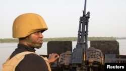 ARCHIVES - Un officier de la marine nigériane sur un bateau au large de la côte atlantique dans l'État de Bayelsa au Nigeria, le 19 décembre 2013.