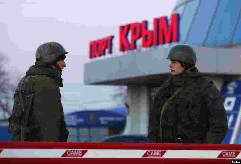 Pria-pria bersenjata, diyakini merupakan tentara Rusia, berdiri di luar pelabuhan sipil di kota Kerch, Krimea (3/3).