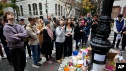 La gente se reúne junto a un monumento improvisado en honor a Matthew Perry afuera del edificio que se muestra en tomas exteriores del programa de televisión "Friends" el lunes 30 de octubre de 2023 en Nueva York.