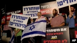 ARSIP – Politisi Israel, Michael Ben Ari, dalam foto yang diambil tanggal 29 Oktober 2013 menggenggam bendera Israel saat menghadiri unjuk rasa atas dibebaskannya tawanan Palestina dari penjara Israel (foto: AP Photo/Bernat Armangue, Arsip)