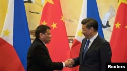 Presiden Filipina Rodrigo Duterte (kiri) dan Presiden China, Xi Jinping, bersalaman setelah upacara penandatanganan di Beijing, 20 Oktober 2016 (foto: REUTERS/Ng Han Guan/Pool)