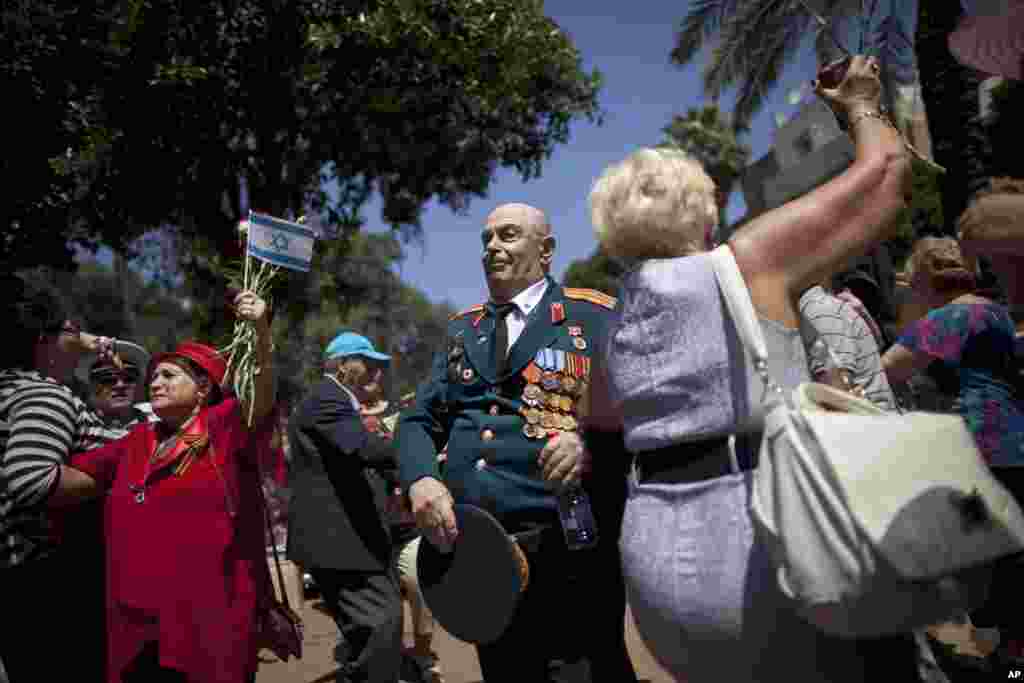 Para veteran Perang Dunia II keturunan Rusia-Israel menari dalam parade jalanan yang menandai hari kemenangan di Haifa, Israel. Para veteran Israel dari bekas Uni Soviet berbaris bersama dengan keluarga mereka untuk merayakan ulang tahun ke-68 kemenangan Sekutu atas Nazi Jerman pada tahun 1945.