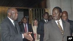 Ivory Coast strongman Laurent Gbagbo, left, talks with Kenyan Prime Minister Raila Odinga, an African Union envoy sent to mediate the ongoing Ivorian political standoff, following a meeting at the presidential palace in Abidjan, Ivory Coast, (January 17,