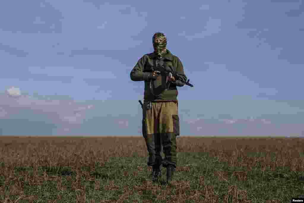 A pro-Russian rebel fighter who calls himself "Hunter," purportedly an American from the state of Illinois, walks through a field near the town of Yasynuvata, in eastern Ukraine, Sept. 26, 2014.