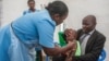 FILE - A health worker administers a typhoid vaccine dose to a boy, as his father holds him, during a typhoid vaccination drive at Ndirande Health Centre in Blantyre, Malawi, Feb. 21, 2018.