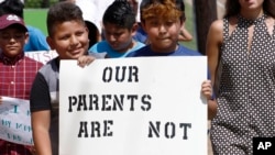 Anak-anak imigran Latin memberikan dukungan kepada orang tua yang ditangkap petugas imigrasi, dengan ikut aksi unjuk rasa ke Gedung Pengadilan Madison di Canton, Mississippi, 11 Agustus 2019.