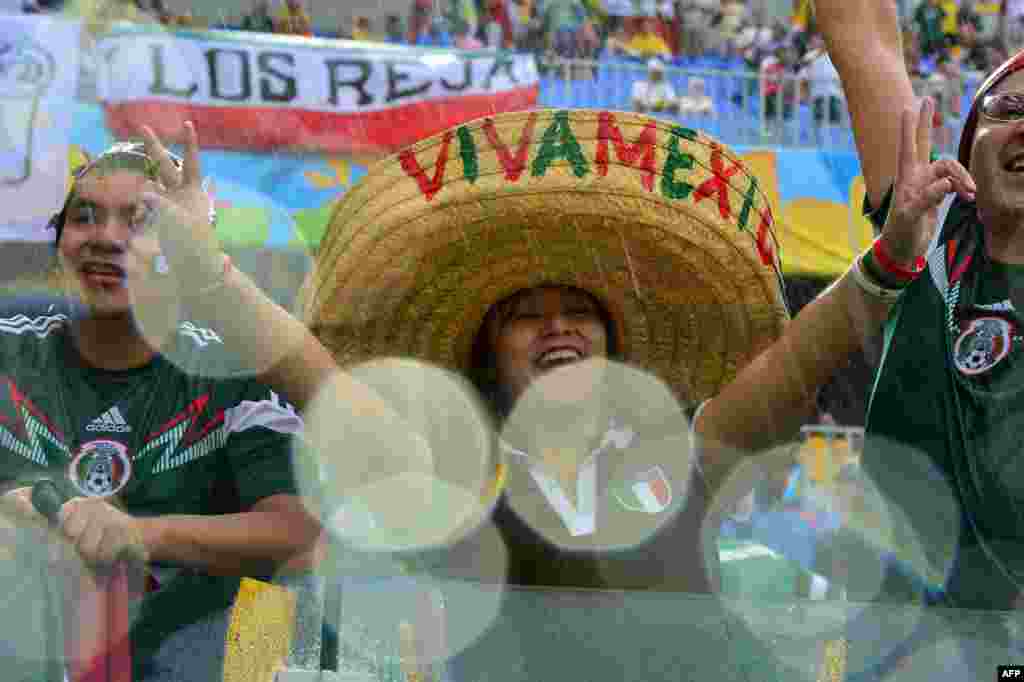 Penggemar sepak bola Meksiko mengelu-elukan tim mereka dalam pertandingan sepak bola Grup A antara Meksiko dan Kamerun di Arena Dunas di Natal, Brazil, dalam Piala Dunia FIFA 2014. 