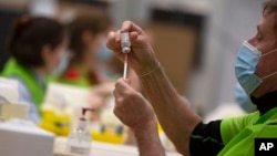 Seorang petugas menyiapkan vaksin COVID-19 produksi AstraZeneca di sebuah klinik kota Antwerpen, di tengah lonjakan kasus COVID-19 di Belgia. 