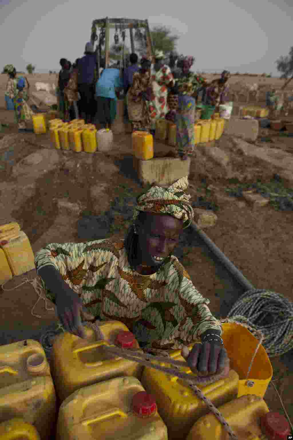  Djiba Ba charge 15 bidons d'eau sur un âne pour les ramener à sa famille et ses animaux, dans le village de Mbelone au nord-est du Sénégal, le1er mai 2012.