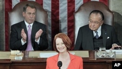 Australian Prime Minister Julia Gillard, center, flanked by Speaker of the House John Boehner, R-Ohio, (l), and Senate President Pro Tempore Daniel Inouye, D-Hawaii, (r), is applauded as she prepares to address a joint meeting of Congress on Capitol Hill 