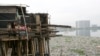 Anak-anak berdiri di dalam rumahnya di atas danau yang tercemar sampah di kawasan kumuh, Jakarta Utara. Presiden Joko Widodo meminta kemiskinan di Tanah Air dientaskan pada 2024. (Foto: REUTERS/Supri)
