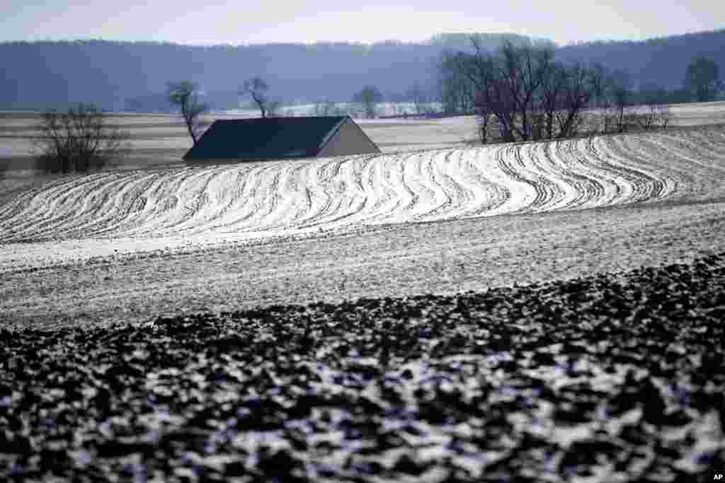 The sun reflects off of snow and ice on a farmer's frozen field in Ronks, Pennsylvania, Jan. 2, 2018.