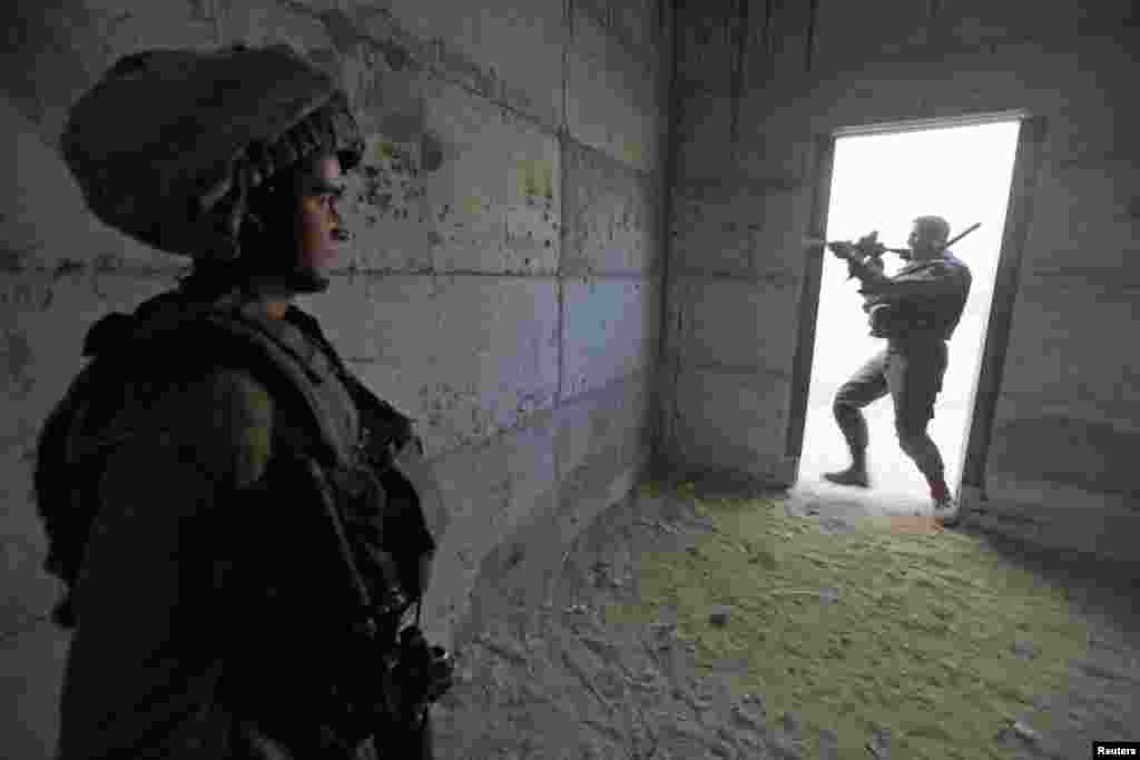 An Israeli soldier runs with his weapon during a drill simulating a possible ground invasion into the Gaza Strip, at a base south of the West Bank city of Hebron, November 17, 2012.