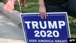 A supporter of US President Donald Trump holds a sign to show their support before the vice presidential debate outside Kingsbury Hall at the University of Utah on October 7, 2020, in Salt Lake City, Utah. (Photo by GEORGE FREY / AFP)