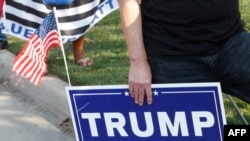 Seorang pendukung Presiden Donald Trump membawa poster untuk menunjukkan dukungan sebelum debat cawapres di Kingsbury Hall, Universitas Utah, 7 Oktober 2020, d Salt Lake City, Utah. (Foto: GEORGE FREY / AFP)