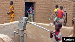 Un enfant pompe de l'eau dans le village de Kouroume, dans le nord du Mali, le 13 mai 2015. (Adama Diarra, Reuters)