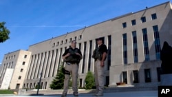 Petugas berjaga-jaga di luar Pengadilan Distrik Federal AS di Washington (28/6), tempat tersangka serangan Benghazi, Ahmed Abu Khattala, disidang. (AP/Jose Luis Magana)