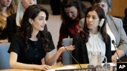 Nadia Murad Basee Taha (kanan) mendengarkan Amal Clooney, pengacara HAM Internasional, berbicara dalam sidang Dewan Keamanan PBB mengenai kekerasan seksual yang digelar di markas PBB, Selasa, 23 April 2019.