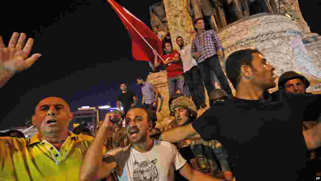 Les partisans du président Recep Tayyip Erdogan protestent devant des soldats sur la place Taksim d'Istanbul, 16 juillet 2016.