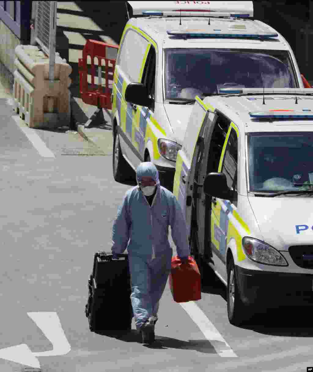 Un policía forense lleva una maleta mientras trabaja en una zona acordonada del área del Puente de Londres donde el sábado por la noche se perpetraron dos ataques que dejaron siete muertos y 48 heridos. Junio 4, 2017.