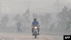 লাহোরে ধোঁয়াশার মধ্য দিয়েই লোকজন যাতায়াত করছেন। ফটোঃ ২ নভেম্বর, ২০২৪।  