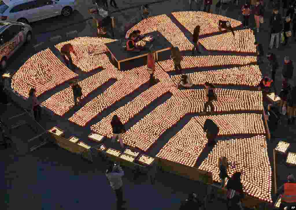 People construct a heart shape using over 12,000 tea candles during the Festival of Lights in Halle (Saale), eastern Germany, Nov. 3, 2013.