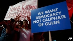Les partisans du président turc, Recep Tayyip Erdogan tiennent une pancarte lors d'un rassemblement pro-gouvernemental sur la place principale Kizilay à Ankara, Turquie, 20 juillet 2016. 