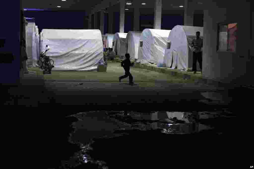 A Syrian boy, who fled his home with his family due to fighting between government forces and rebels, plays near his tent at a refugee camp near the Turkish border, Azaz, Syria, October 7, 2012.