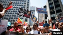 Plusieurs centaines de demandeurs d'asile érythréens en Israël ont manifesté en tenant des pancartes pour soutenir le nouveau rapport de l'ONU sur l'Erythrée sur les crimes comis par les belligerents du pays, Israël, le 21 juin 2016.