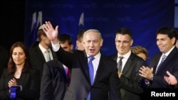 PM Israel Benjamin Netanyahu melambaikan tangan ke arah para pendukungnya didampingi anggota partainya di kantor pusat partai Likuddi Tel Aviv January 23, 2013. (REUTERS/Nir Elias) 