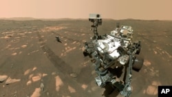 Esta imagen proporcionada por la NASA el 6 de abril de 2021, muestra a la sonda Perseverance en primer plano y al helicóptero Ingenuity unos 3,9 metros detrás. 
